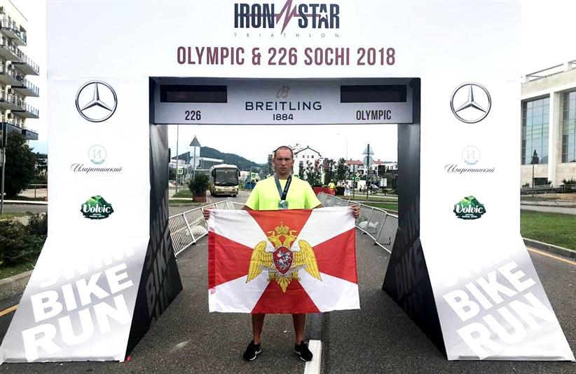 Росгвардеец развернул флаг с символикой ведомства на финише соревнований по триатлону «Ironstar 226 Sochi»