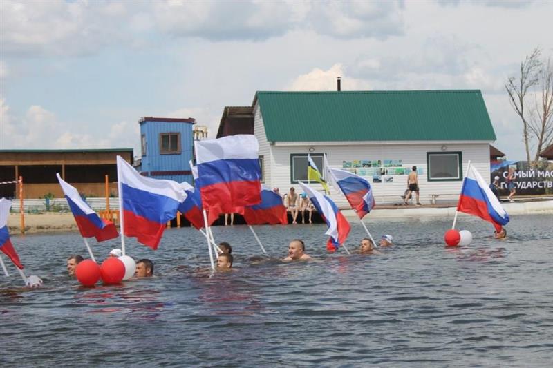 В Тюмени в День России офицер Росгвардии принял участие в массовом заплыве с флагами государства