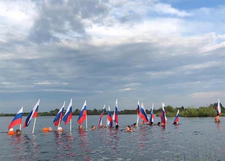 В Тюмени в День России офицер Росгвардии принял участие в массовом заплыве с флагами государства