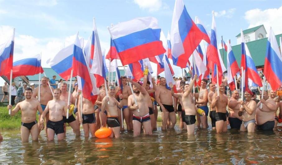 В Тюмени в День России офицер Росгвардии принял участие в массовом заплыве с флагами государства