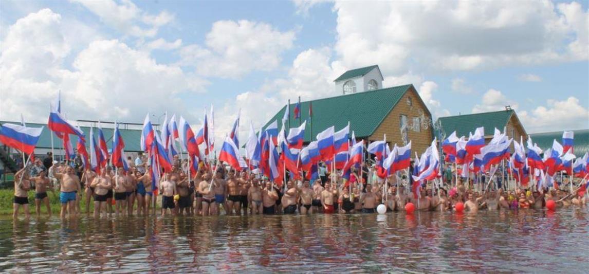В Тюмени в День России офицер Росгвардии принял участие в массовом заплыве с флагами государства